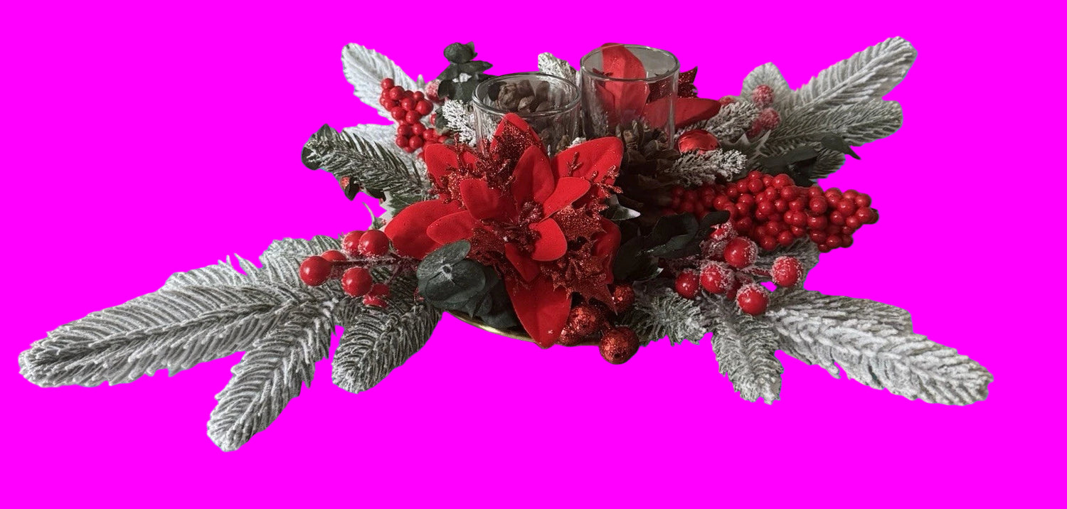 Decorative floral arrangement with red flowers and berries on a neutral surface